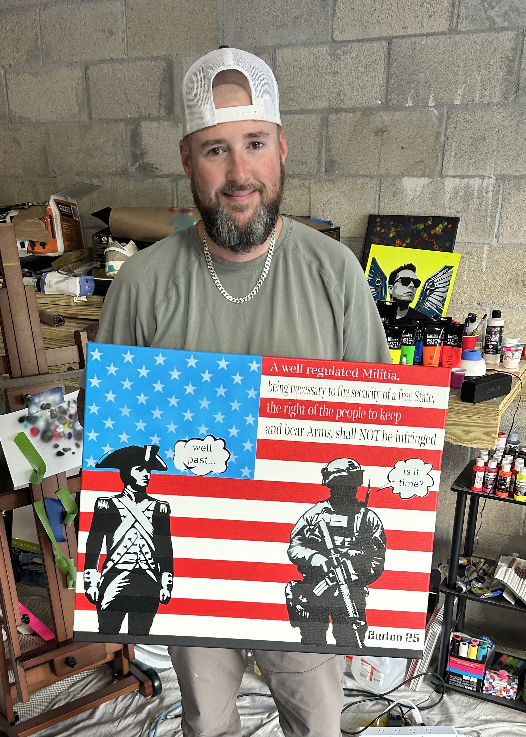 Jeremy Burton in his studio holding one of his pop-art canvases